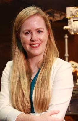 Laurie Barge, a white skinned woman with long blonde hair and wearing a white long sleeve cardigan, smiling at the camera