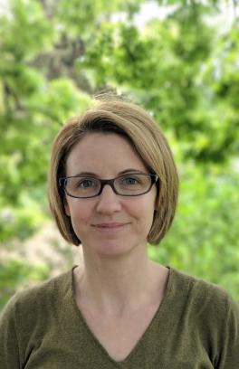Professional head shot of Marilyne Stains, a white woman with short blonde hair and glasses.