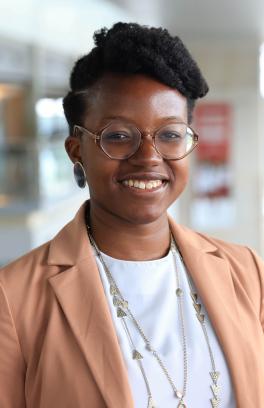 A professional headshot of Lyniesha Ward, a black person with short styled black hair and round glasses, smiling at the camera.