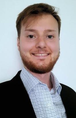 A headshot of Jake Nicholson, a white man with short red hair and beard. 