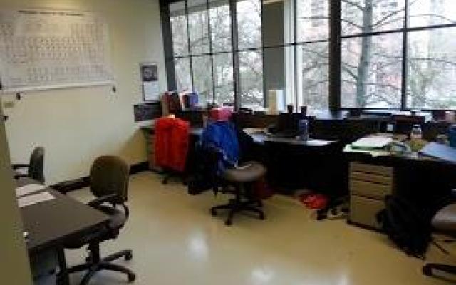 A few desks sit empty in front of a window.