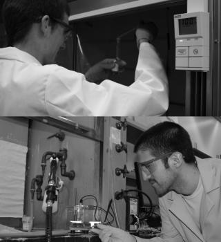 Man in white lab coat works with instruments in a chemical hood.