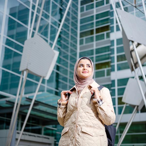 graduate student standing in front of a building