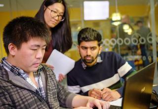 three students looking at a computer screen