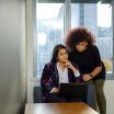 two people look at a laptop, puzzled