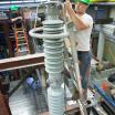 a researcher on a ladder, measuring a tall instrument