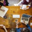 four people having a meeting around a table