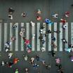 Birds-eye view of a crosswalk, with scattered pedestrians passing in both directions.