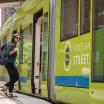 a woman walks into the open doors of a streetcar