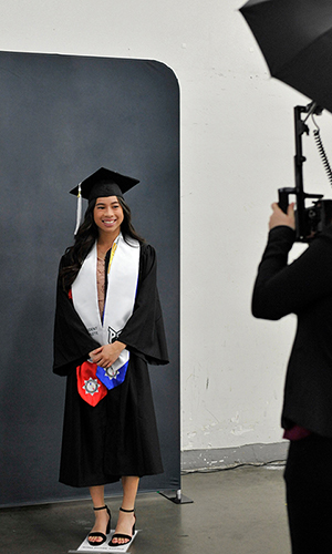 PSU student posing for a photo in commencement regalia