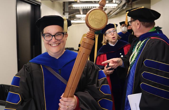Faculty member carries mace in procession
