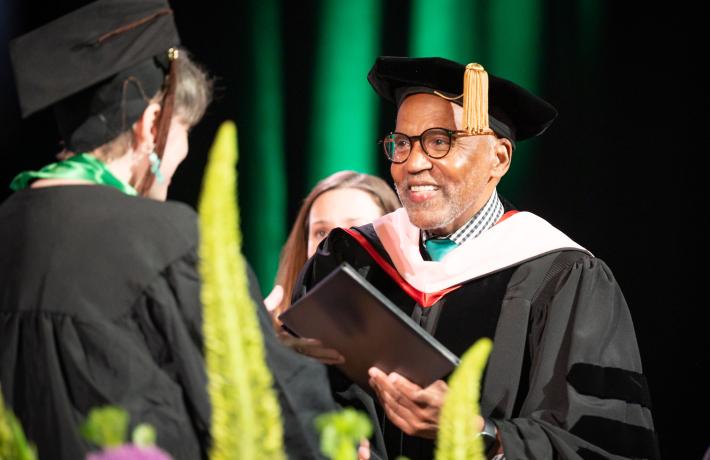 Dean gives student diploma