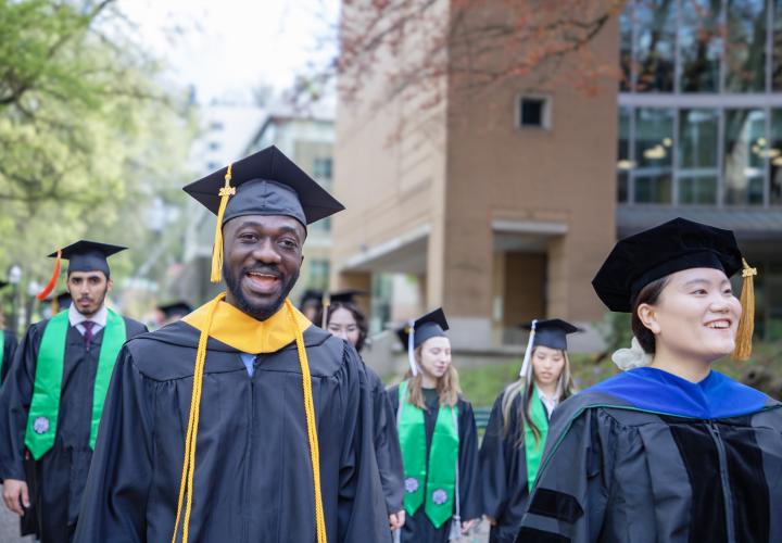 Graduates process in caps and gowns at PSU commencement