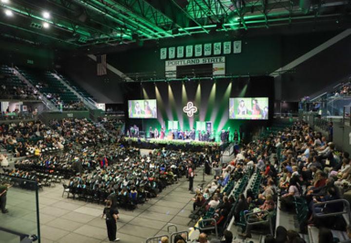 Wide view of College of Education Commencement Ceremony inside Viking Pavilion with audience and stage