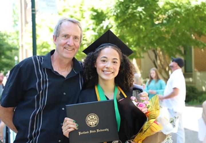 Graduate from The School of Business poses with a family member after commencement