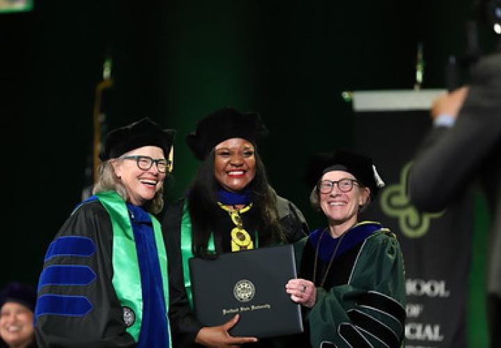 School of Social Work Ph.D. candidate poses with her adviser and PSU president during commencement