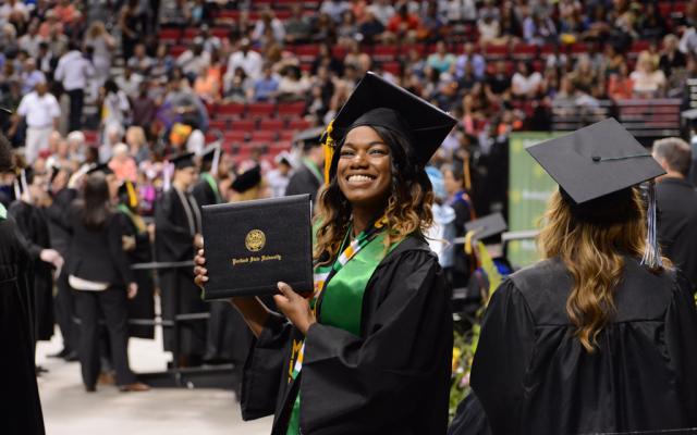 Student showing her diploma at commencement