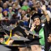 Student waiving to family at commencement