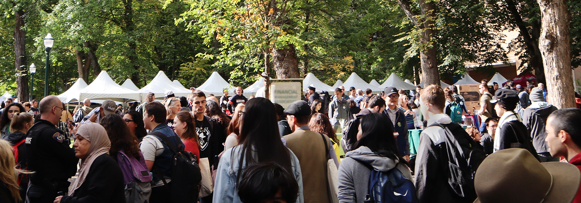 A crowd mingles between tents and tables at Party in the Park on a sunny day in the Park Blocks near Smith. Party in the Park is an annual event at Portland State University. 