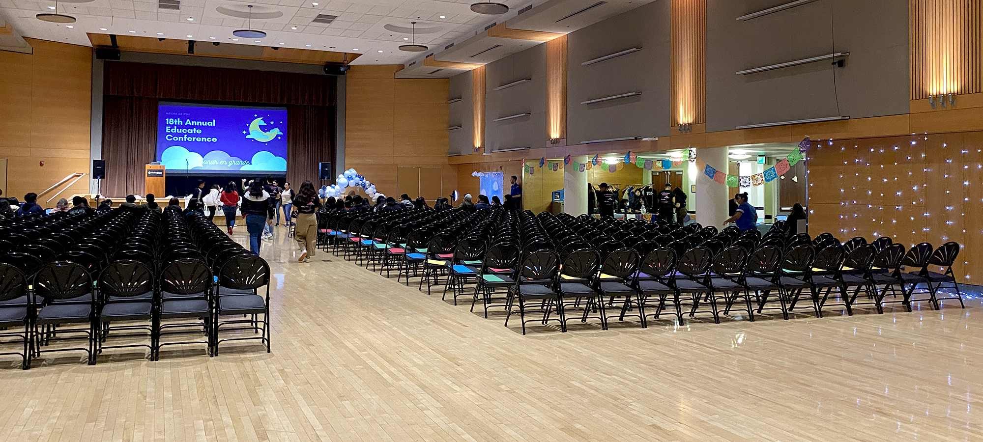 The ballroom in Smith set for an event with rows of chairs, stage and podium.