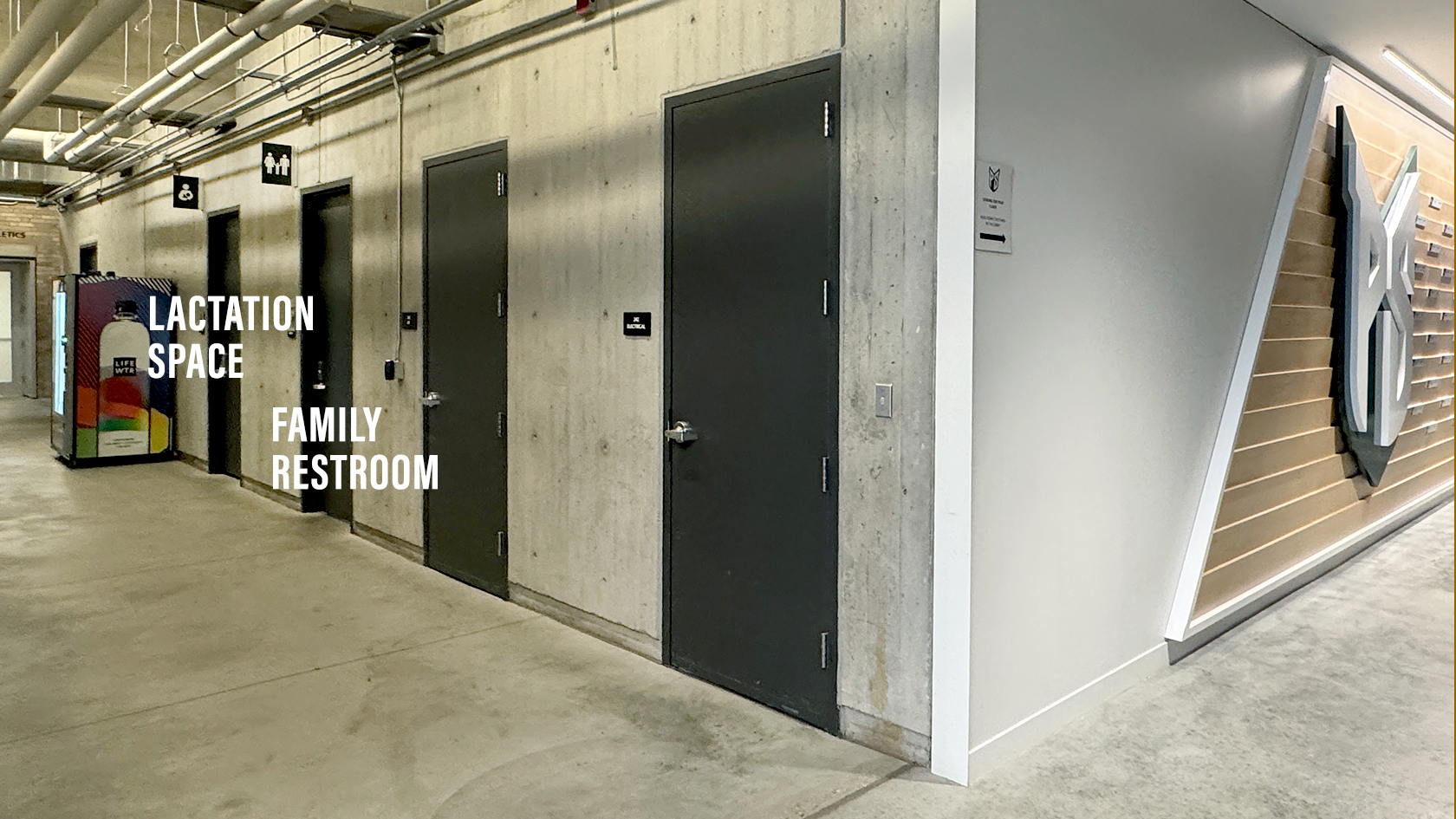 Shows corridor west of Arena where the family restroom -- third door in hall -- and lactation space -- fourth door -- are located. Viking doors have raised letters to the left of most doors.