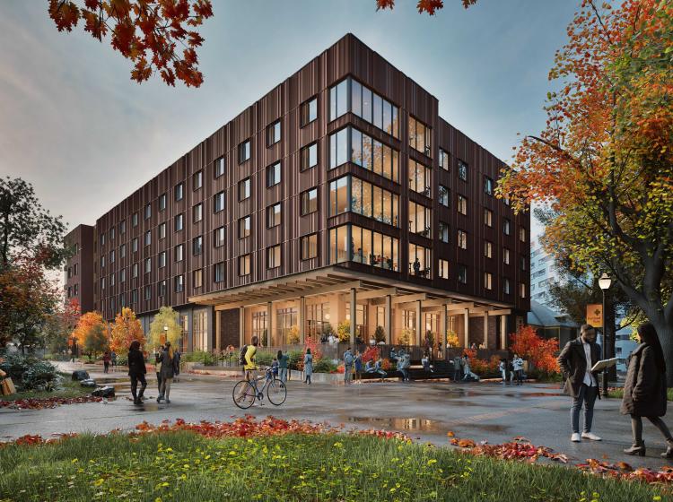 picture of psu new housing building. brown building with many people standing in front with fall foliage