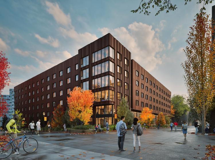 picture of psu new housing building. brown building with many people standing in front with fall foliage