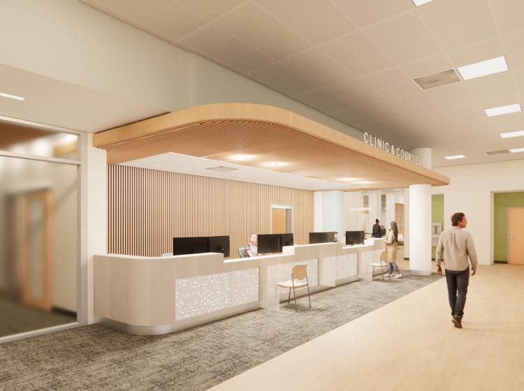 Main reception area with long reception desk and people walking down hall.