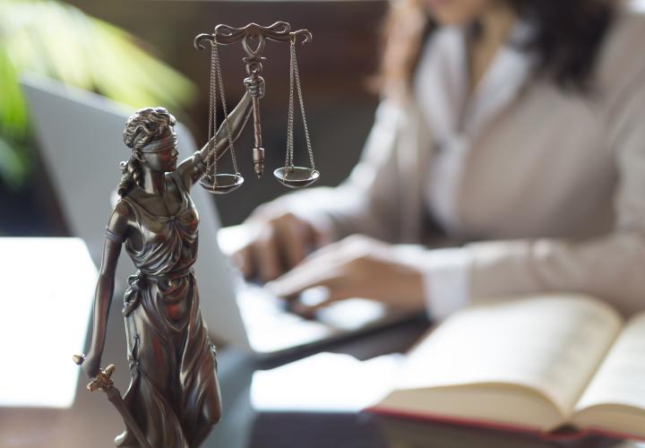 Statue of Justice; Lawyer working on laptop