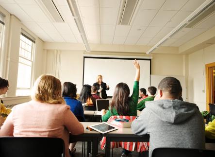 Student with raised hand in classroom