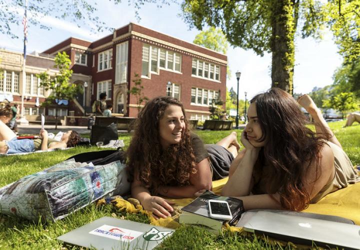 Students sitting in the grass in the Park Blocks of PSU's campus.