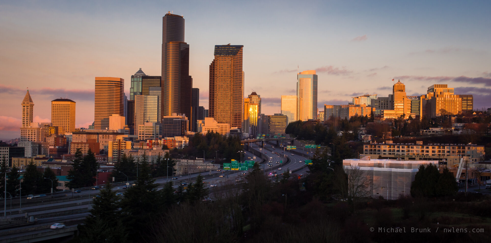 The Portland skyline viewed from the south, with light from the sunset reflecting off downtown buildings