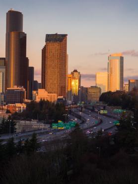 The Portland skyline viewed from the south, with light from the sunset reflecting off downtown buildings