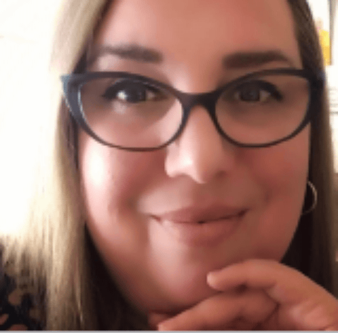 Photo of Lynda España. Lynda has blonde hair and wears glasses.