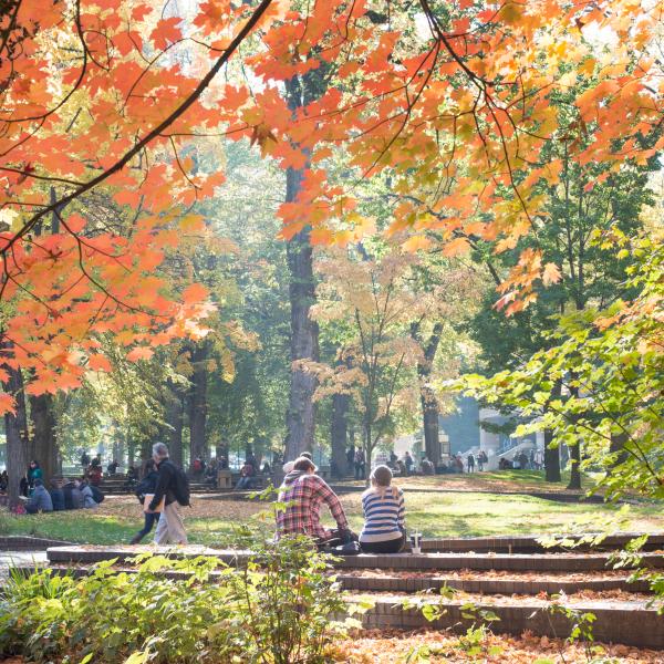 Two people sitting next to each other in a courtyard.