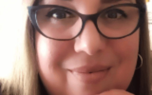 Photo of Lynda España. Lynda has blonde hair and wears glasses.