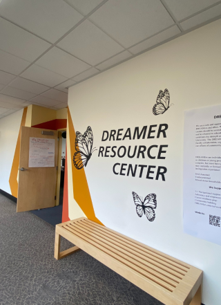 Photo showing entrance with a Dreamer Resource Center sign surrounded by monarch butterflies