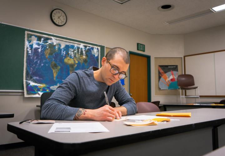 Student filling out tags that represent migrants crossing the border