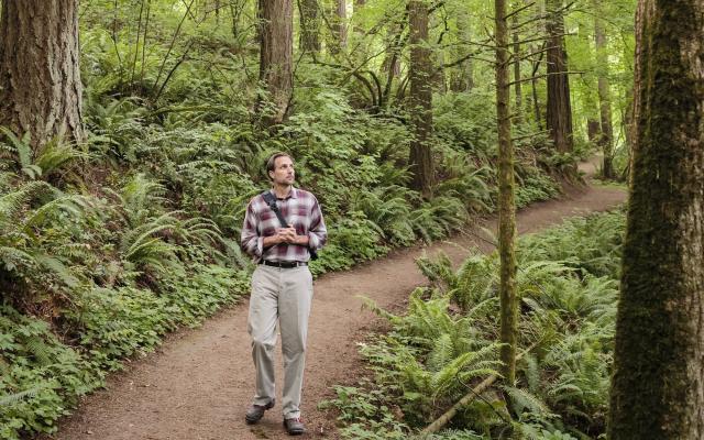 Man walking on trail in forest
