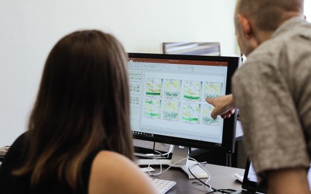 Professor and student looking at climate models on computer