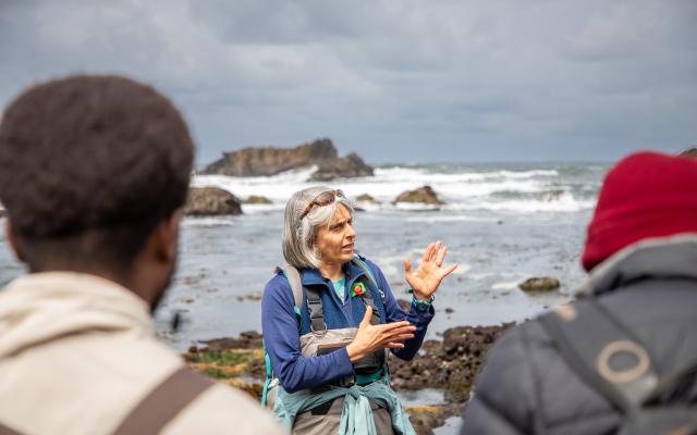 Professor talking to class with ocean in background