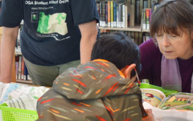 Teacher overseeing activity with maps