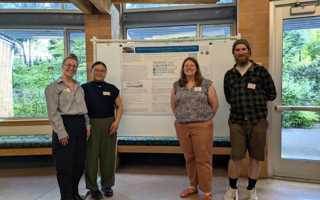 Professor and students in front of research poster