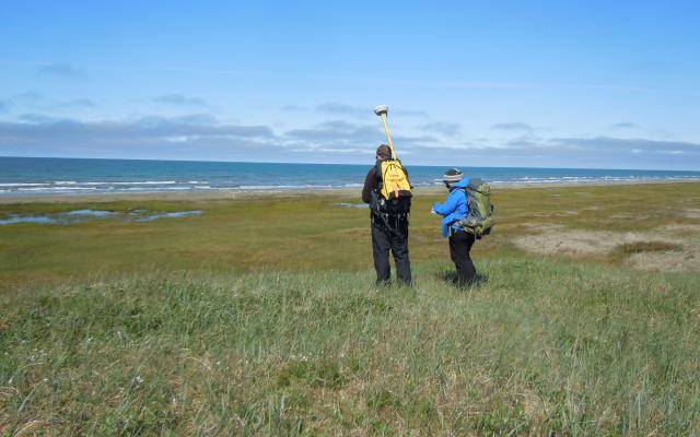 Two researchers out on grassy field