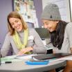 Smiling female advisor meeting with smiling female student.