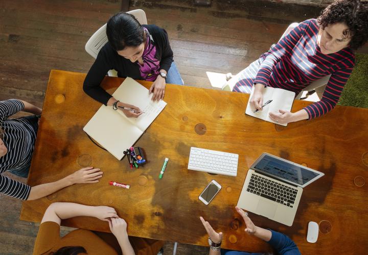 View from above of students working together at a wood desk