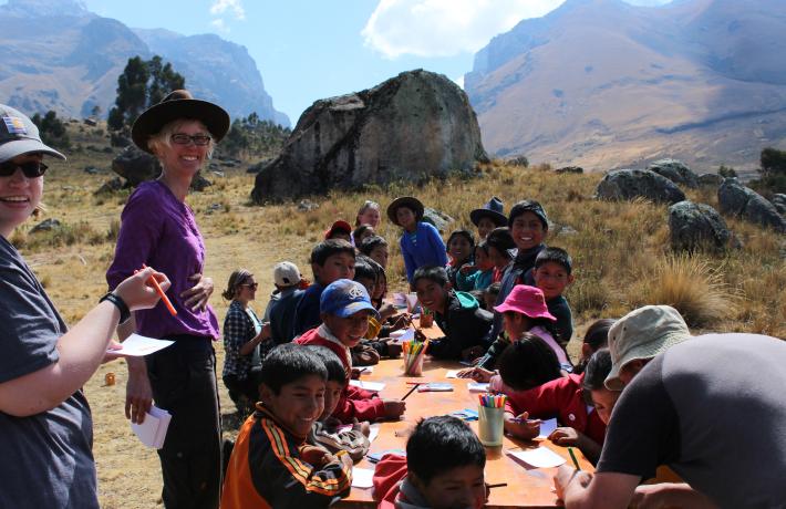 school children writing at table outside