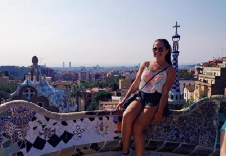 Woman sitting on mosaic wall