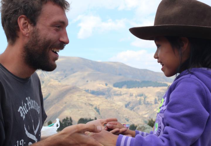 PSU student holding hands with child in Peru