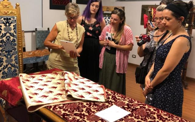 people looking at a notebook and piece of fabric
